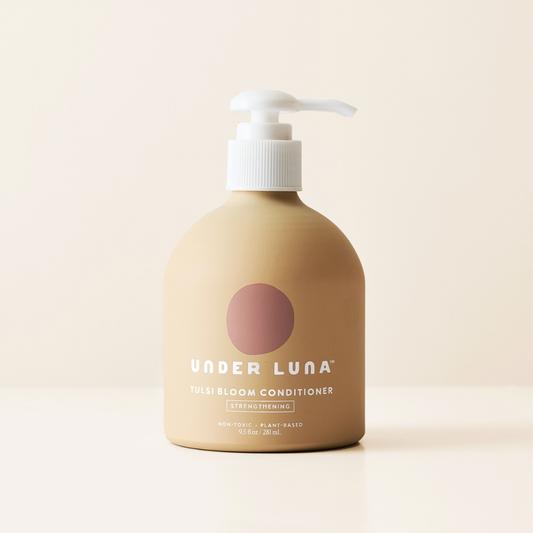 A bottle of Under Luna Tulsi Bloom Conditioner with a pump dispenser, labeled with the brand and product name.